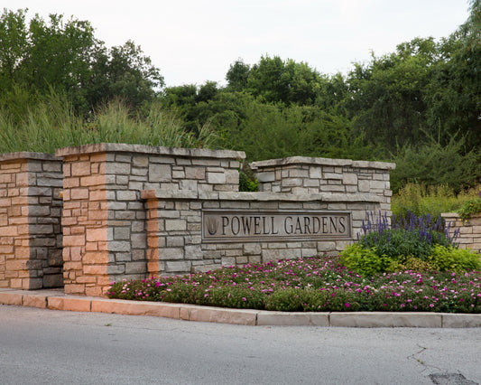 Powell Gardens stone entrance sign surrounded by colorful summer flower beds near Kansas City Missouri
