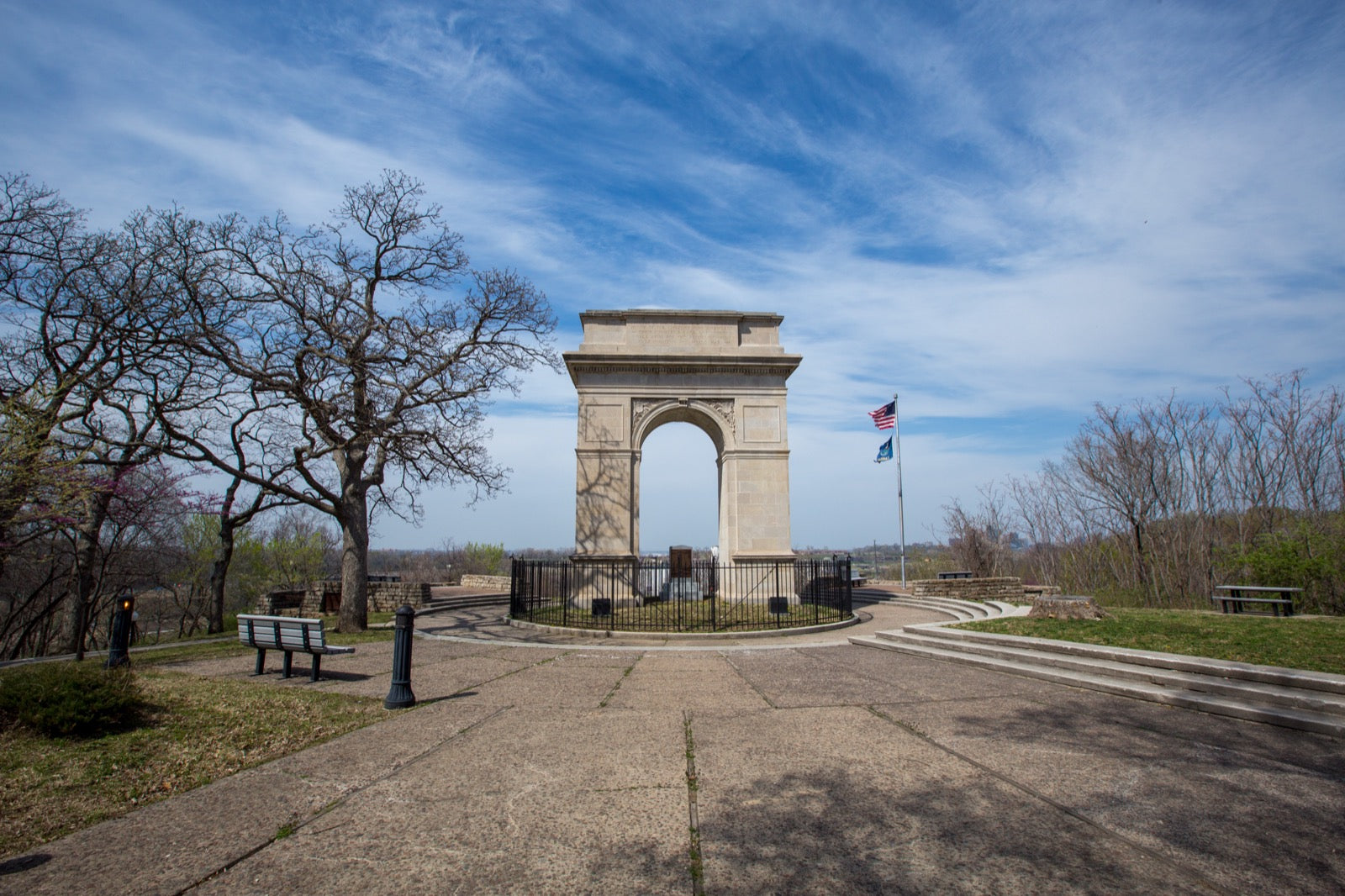 Rosedale Memorial Arch with American flag under dramatic blue sky and walkway in Kansas City Kansas