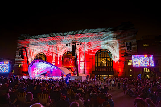 Kansas City Symphony Memorial Day concert at Union Station with red white and blue patriotic lighting and large crowd at night