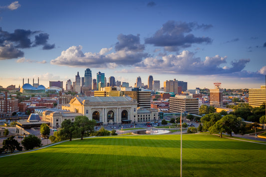 Union Station and the Kansas City Missouri downtown skyline from the Liberty Memorial lawn at golden hour with dramatic clouds