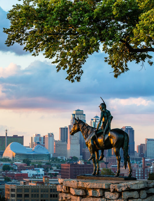 The Scout bronze statue on horseback overlooking the Kansas City Missouri downtown skyline at golden hour from Penn Valley Park